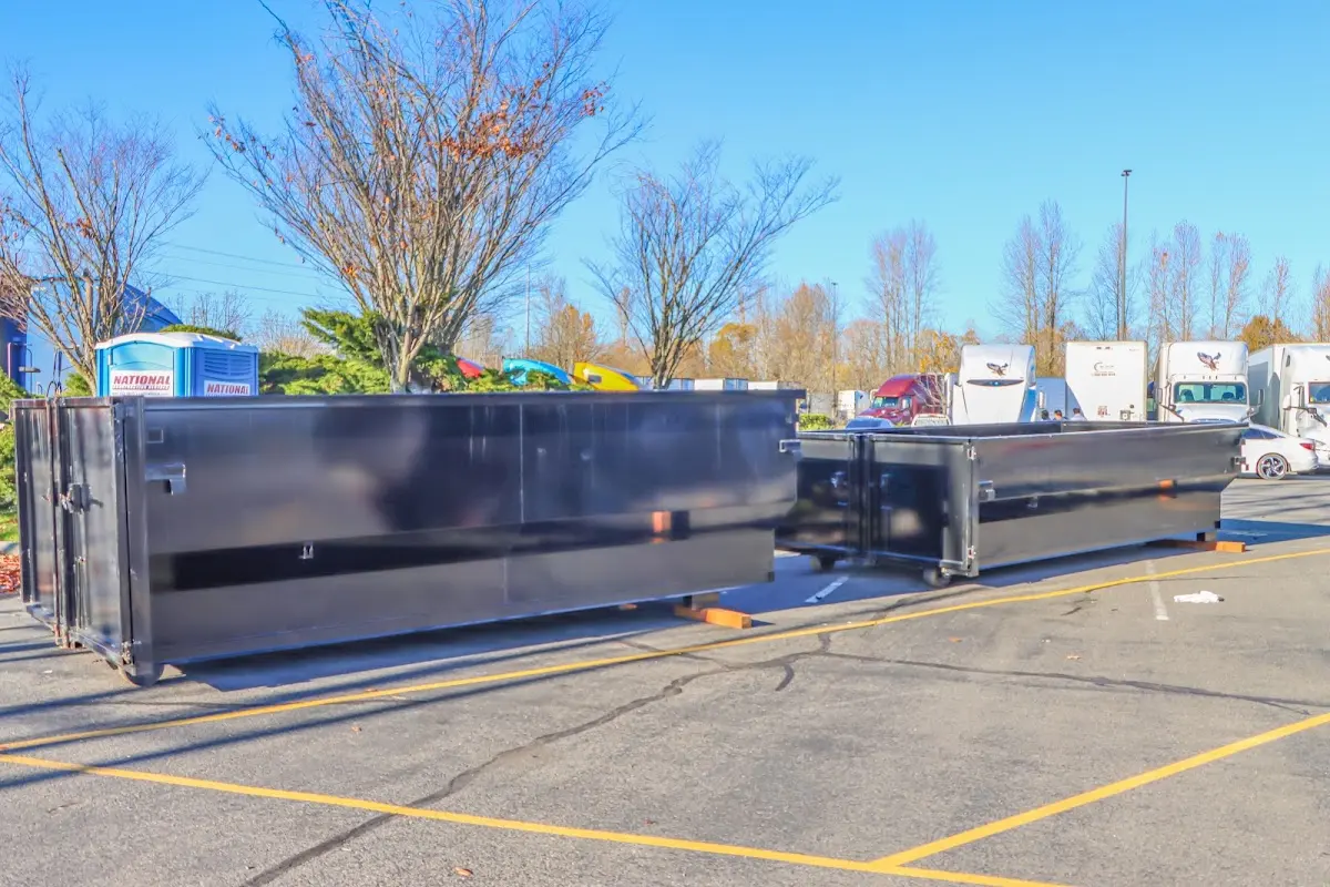 Professional dumpster rental service with roll-off container on residential driveway in Graham